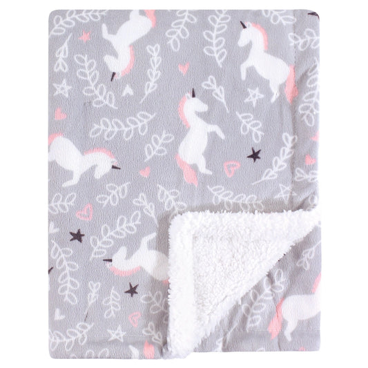 Unicorn patterned blanket with white reverse side on a gray background