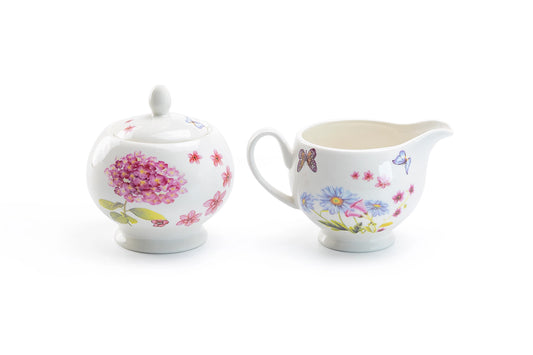 Floral-patterned sugar bowl and creamer set on a white background