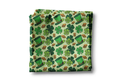 Folded fabric with green shamrock and pot of gold pattern on a white background
