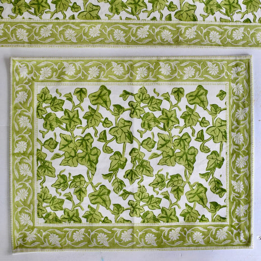 Green leaf patterned fabric with white floral border on a white background