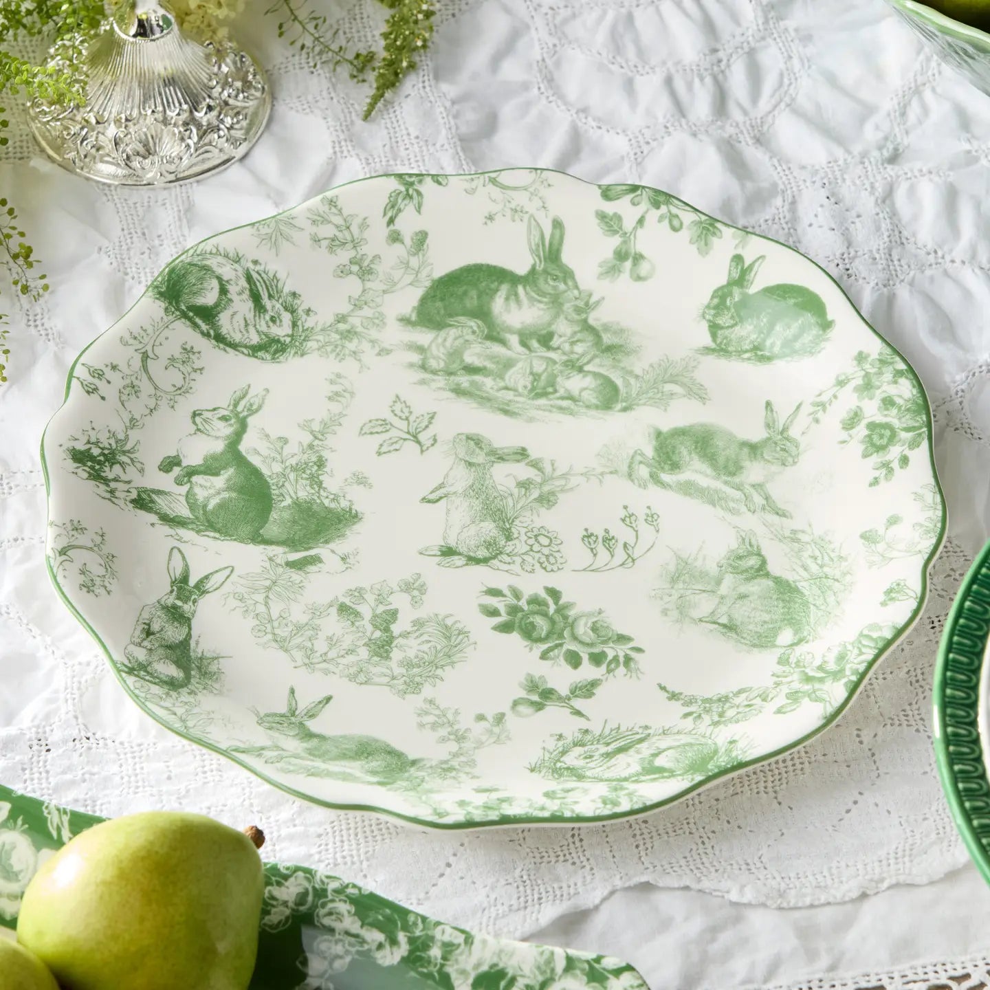 Decorative plate with green rabbit pattern on a white lace tablecloth
