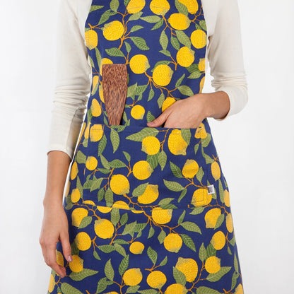 Person wearing a blue apron with yellow lemon pattern on a white background