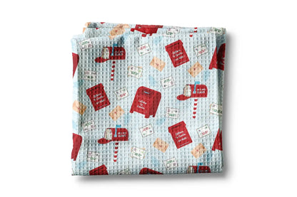 Folded fabric with red book and envelope pattern on a light blue background