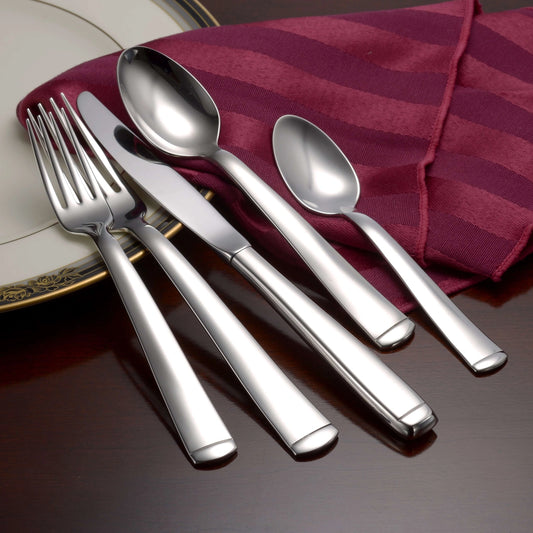 Set of silver cutlery including forks and spoons on a red striped cloth.