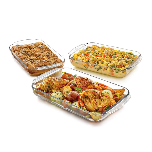 Three glass baking dishes with different types of food on a white background