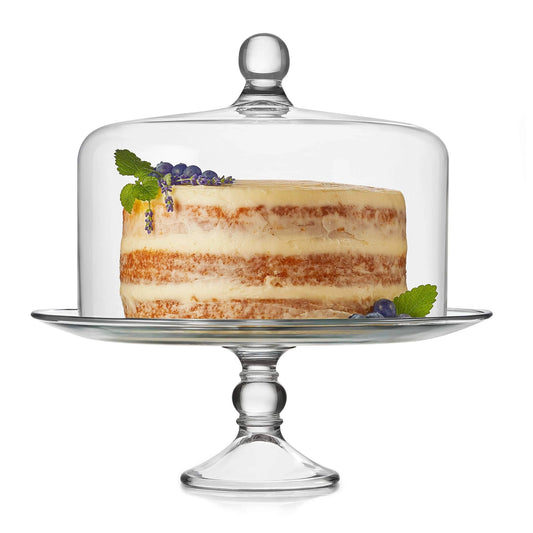 Glass cake stand with a layered cake on a white background
