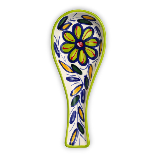 A ceramic spoon with a hand-painted floral design in yellow, blue, green, and red on a white background, featuring a lime green rim.