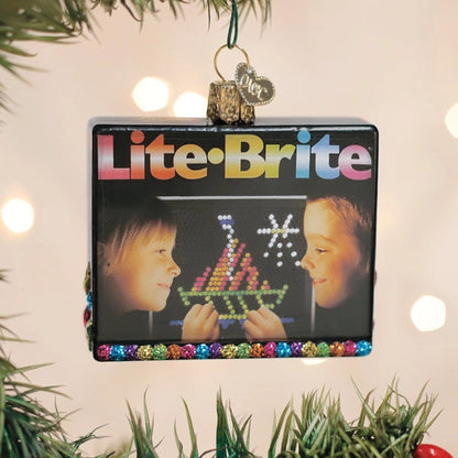 Lite-Brite toy box ornament hanging on a Christmas tree.