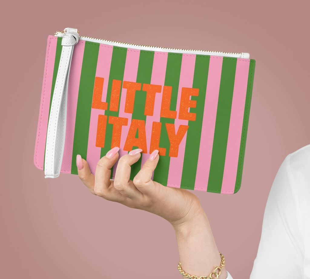 Woman holding colorful Little Italy striped wristlet clutch