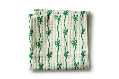 Waffle-textured towel with green bow pattern on a white background