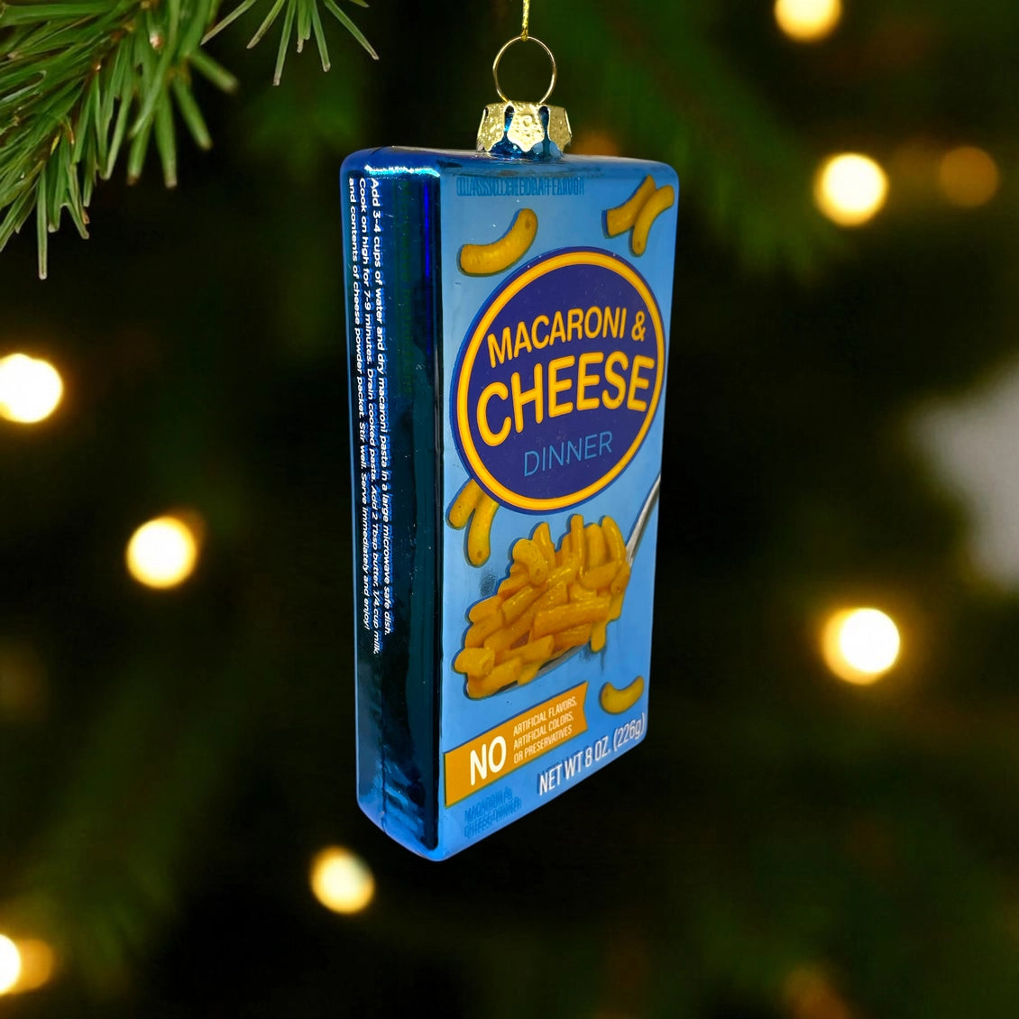 Macaroni and cheese box ornament hanging on a Christmas tree.