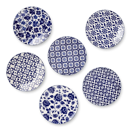 Set of six blue and white patterned plates on a white background