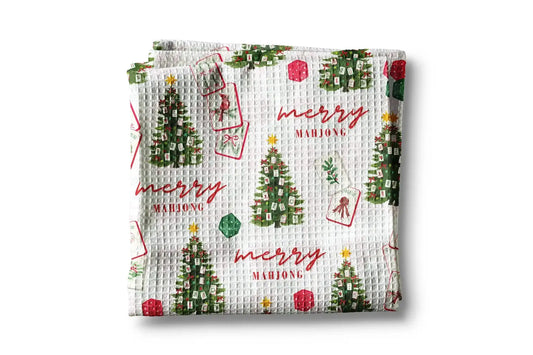 Waffle-textured towel with Christmas tree and 'merry mahjong' pattern on a white background