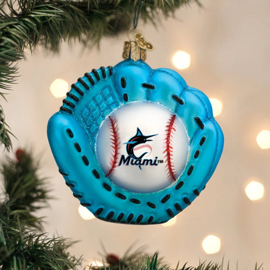 Blue baseball glove ornament with a ball inside, featuring the Miami Marlins logo, hanging on a Christmas tree.