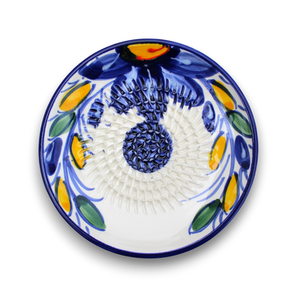 A round white ceramic plate with a hand-painted traditional Mediterranean floral pattern in cobalt blue, yellow, and green, shown from a top-down view on a white background.