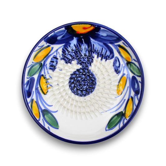 A round white ceramic plate with a hand-painted traditional Mediterranean floral pattern in cobalt blue, yellow, and green, shown from a top-down view on a white background.