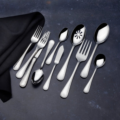 Set of silver flatware including spoons and forks on a dark surface with a black napkin.