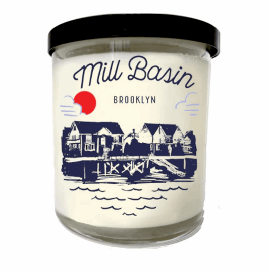 Candle with 'Mill Basin Brooklyn' label featuring a scenic illustration on a white background