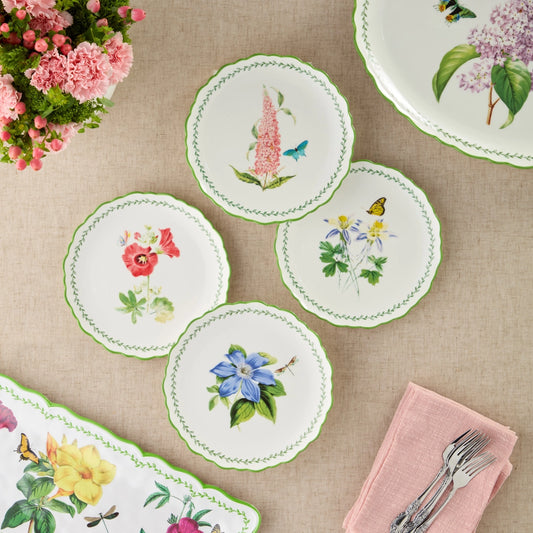 Set of floral coasters on a table with a pink napkin and silverware.