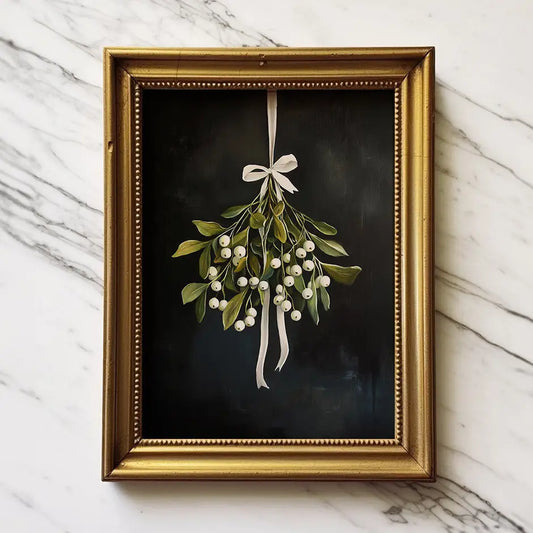 Framed artwork of a mistletoe plant with a gold frame on a marble surface