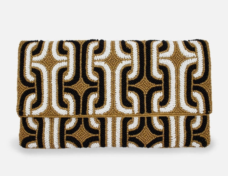 Patterned clutch bag with black, gold, and white design on a white background
