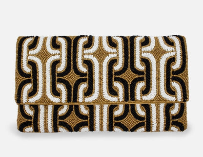 Patterned clutch bag with black, gold, and white design on a white background