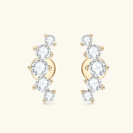Gold earrings with clear gemstones on a white background