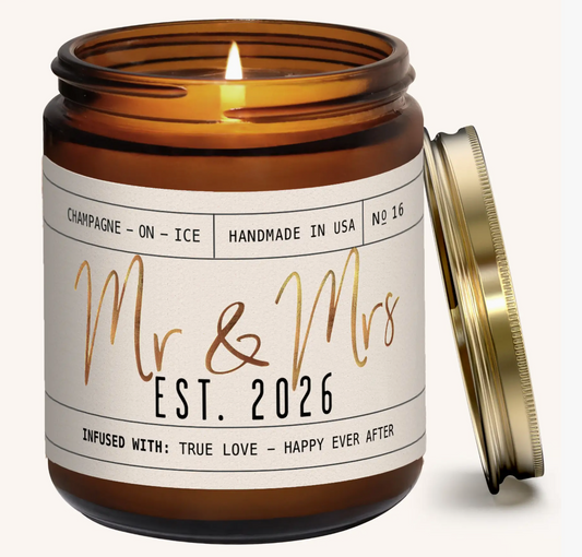 Candle in an amber jar with a 'Mr & Mrs Est. 2026' label on a white background