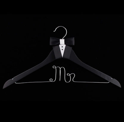 Black hanger with 'Mr' text and bow tie on a black background