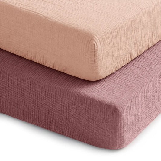 Two textured fitted sheets in pink and red on a white background