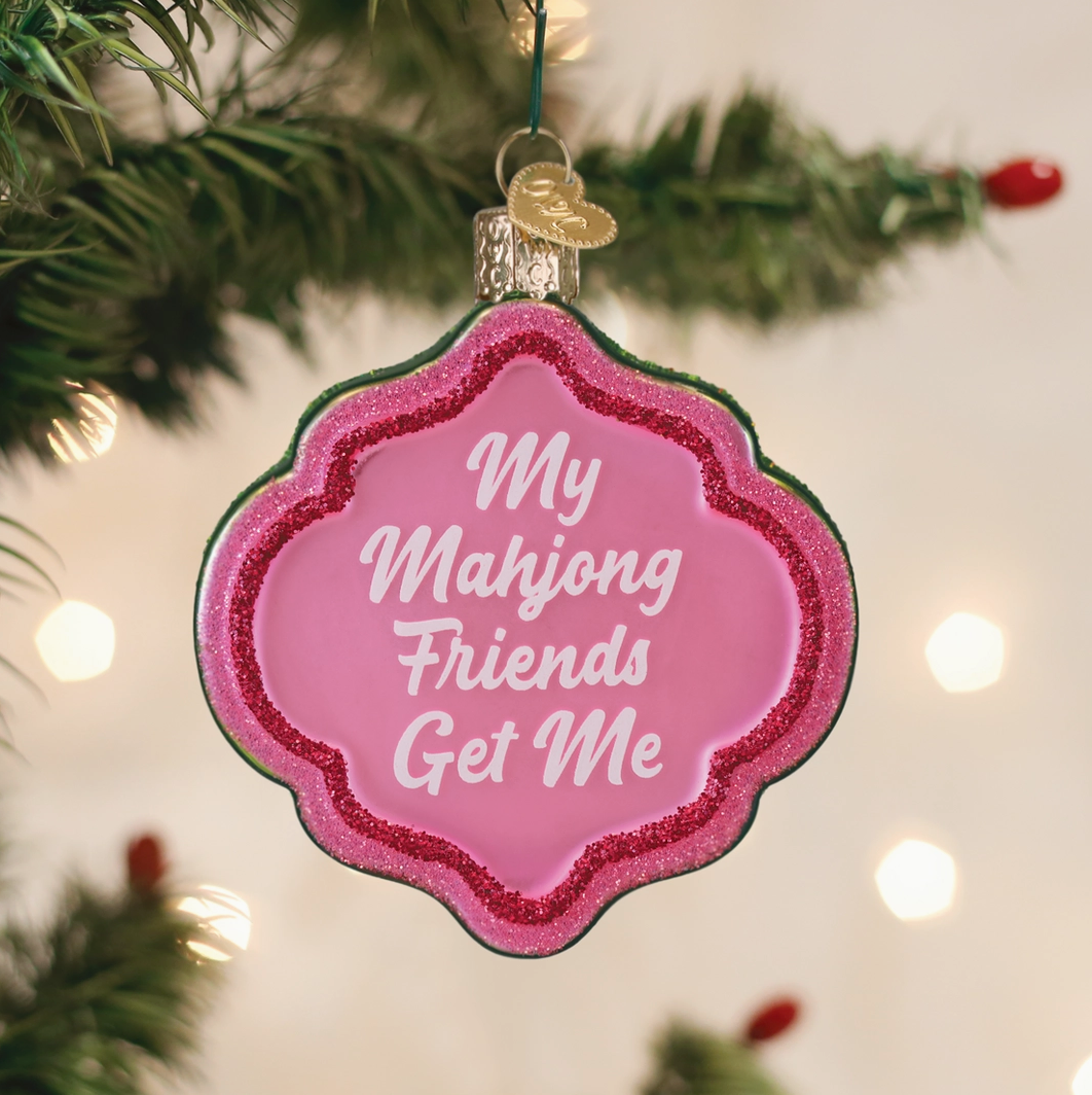 Pink glitter Mahjong Christmas ornament reading My Mahjong Friends Get Me hanging on a Christmas tree