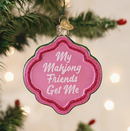 Pink glitter Mahjong Christmas ornament reading My Mahjong Friends Get Me hanging on a Christmas tree