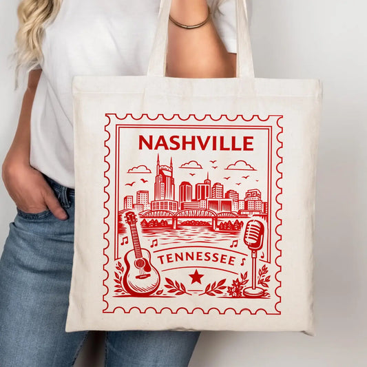 Tote bag with 'Nashville, Tennessee' design featuring a cityscape, guitar, and microphone.