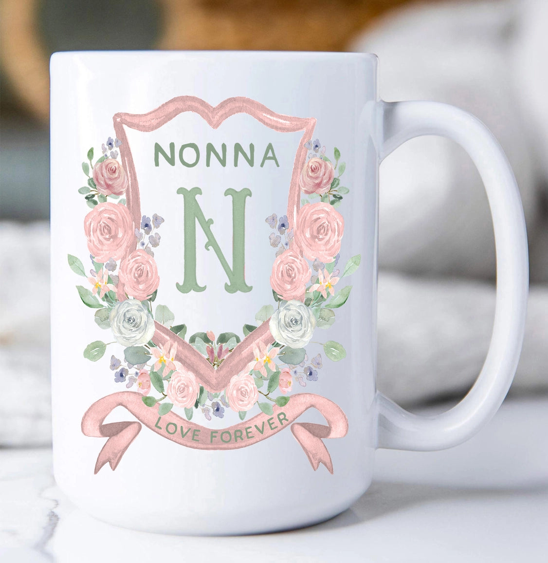 White mug with floral design and 'NONNA N LOVE FOREVER' text on a blurred background