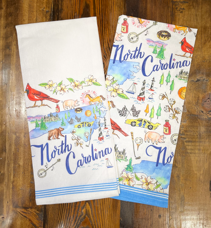Two North Carolina-themed kitchen towels on a wooden surface