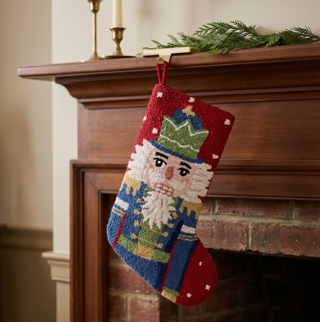 Hand-hooked wool Nutcracker Christmas stocking hanging from traditional wood fireplace mantel