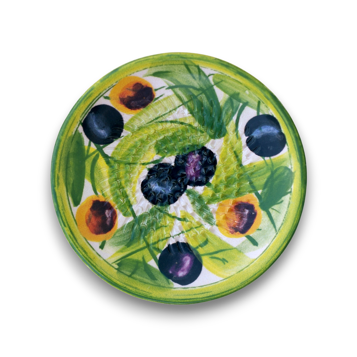 A round ceramic plate featuring a hand-painted design of green leaves, yellow-orange peaches, and dark blue-black plums on a white background, shown from a top-down view against a white backdrop.