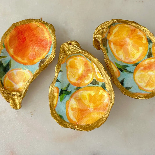 Decorative oyster shells with orange slices on a light background