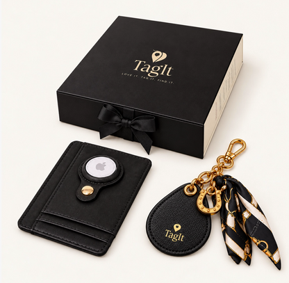 Black leather wallet and matching horseshoe keychain with black-and-cream printed scarf and gold-tone hardware displayed beside an elegant gift box.