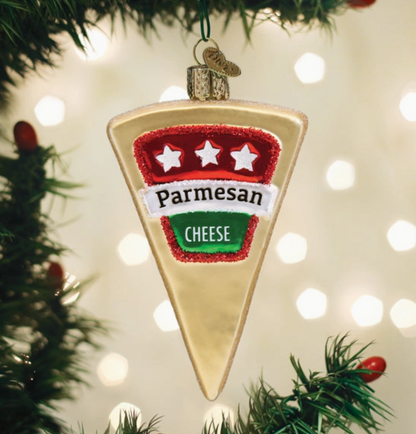 Parmesan cheese wedge glass Christmas ornament with red white and green label hanging on a Christmas tree