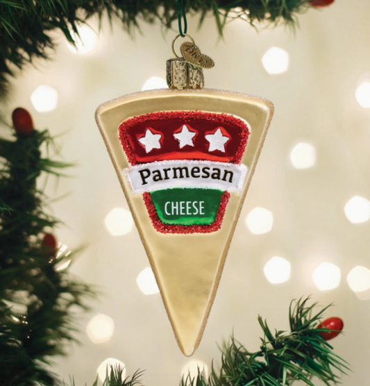 Parmesan cheese wedge glass Christmas ornament with red white and green label hanging on a Christmas tree