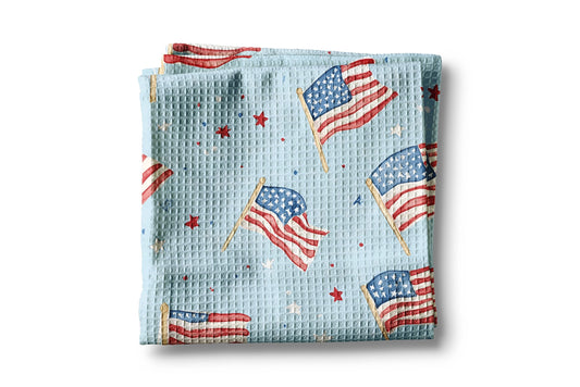 Folded blanket with American flag pattern on a light blue background