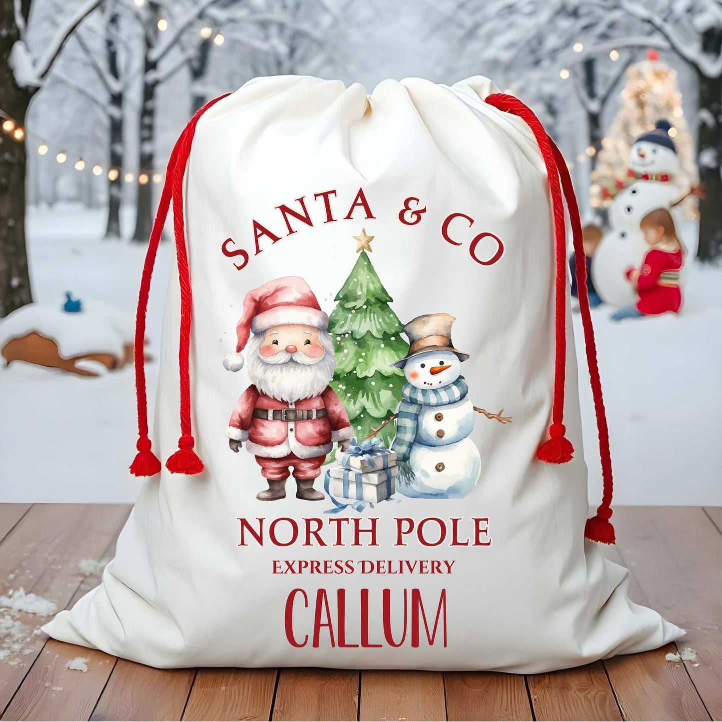 Personalized Santa sack with festive design and text on a wooden floor with a snowy background.