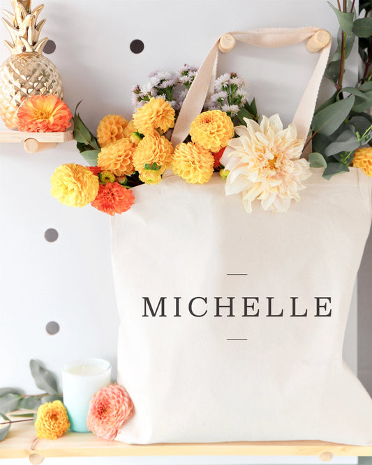 Tote bag with flowers and 'MICHELLE' branding on a decorative background