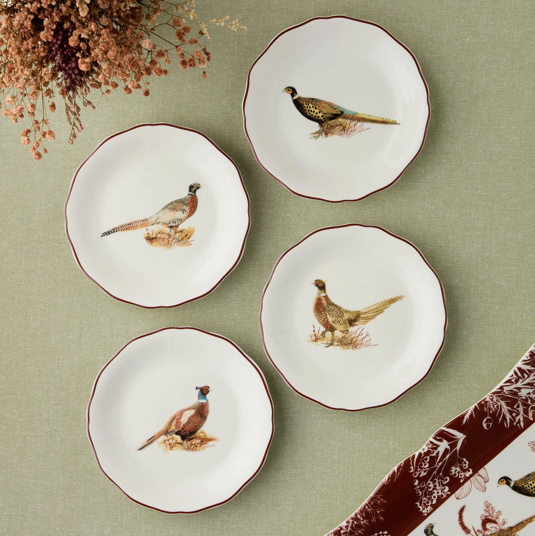 Set of four ceramic plates with pheasant designs on a green background