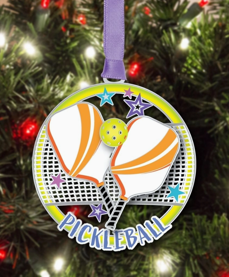 Decorative pickleball ornament with racquets and ball on a Christmas tree.