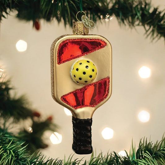 Pickleball paddle ornament on a Christmas tree with lights in the background