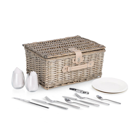 Wicker picnic basket with cutlery, plates, and glasses on a white background