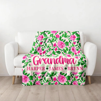 Floral patterned blanket with personalized names on a white armchair.