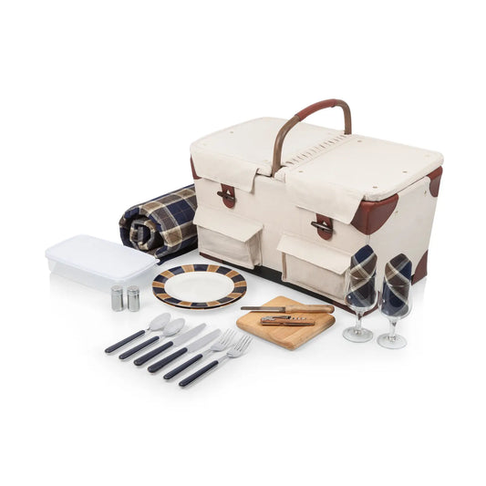 Picnic basket set with blanket, plates, cutlery, and glasses on a white background